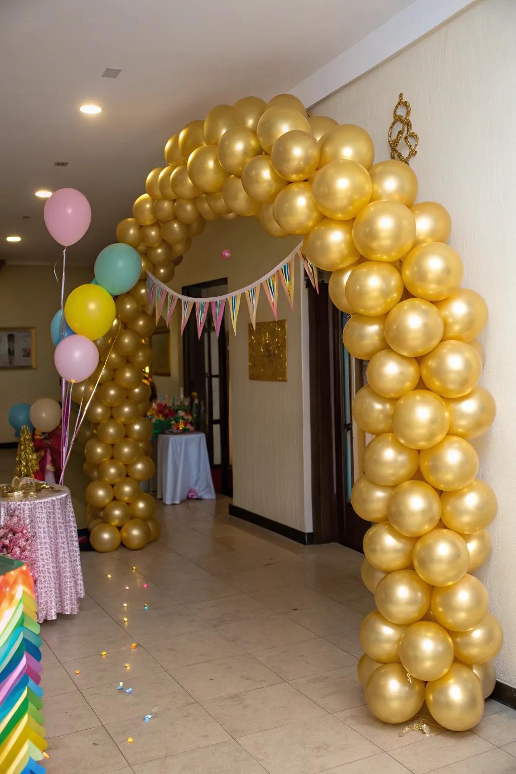 An astonishing gold balloon arch framing a grand entrance.
