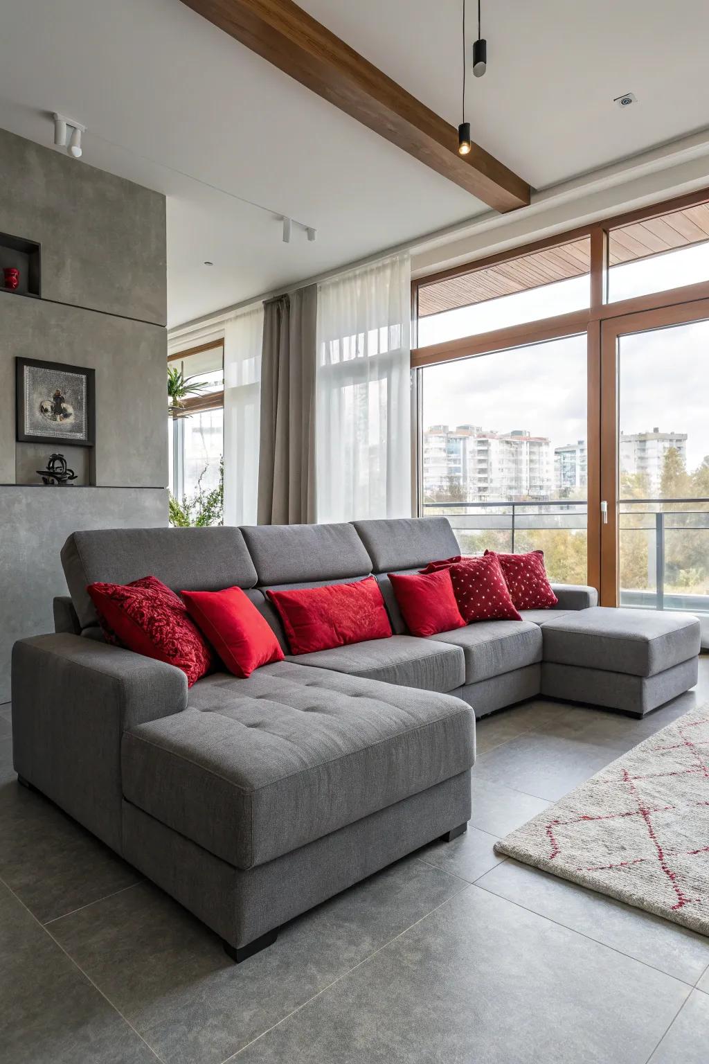 A welcoming living area showcasing a grey modular sofa and crimson pillows.