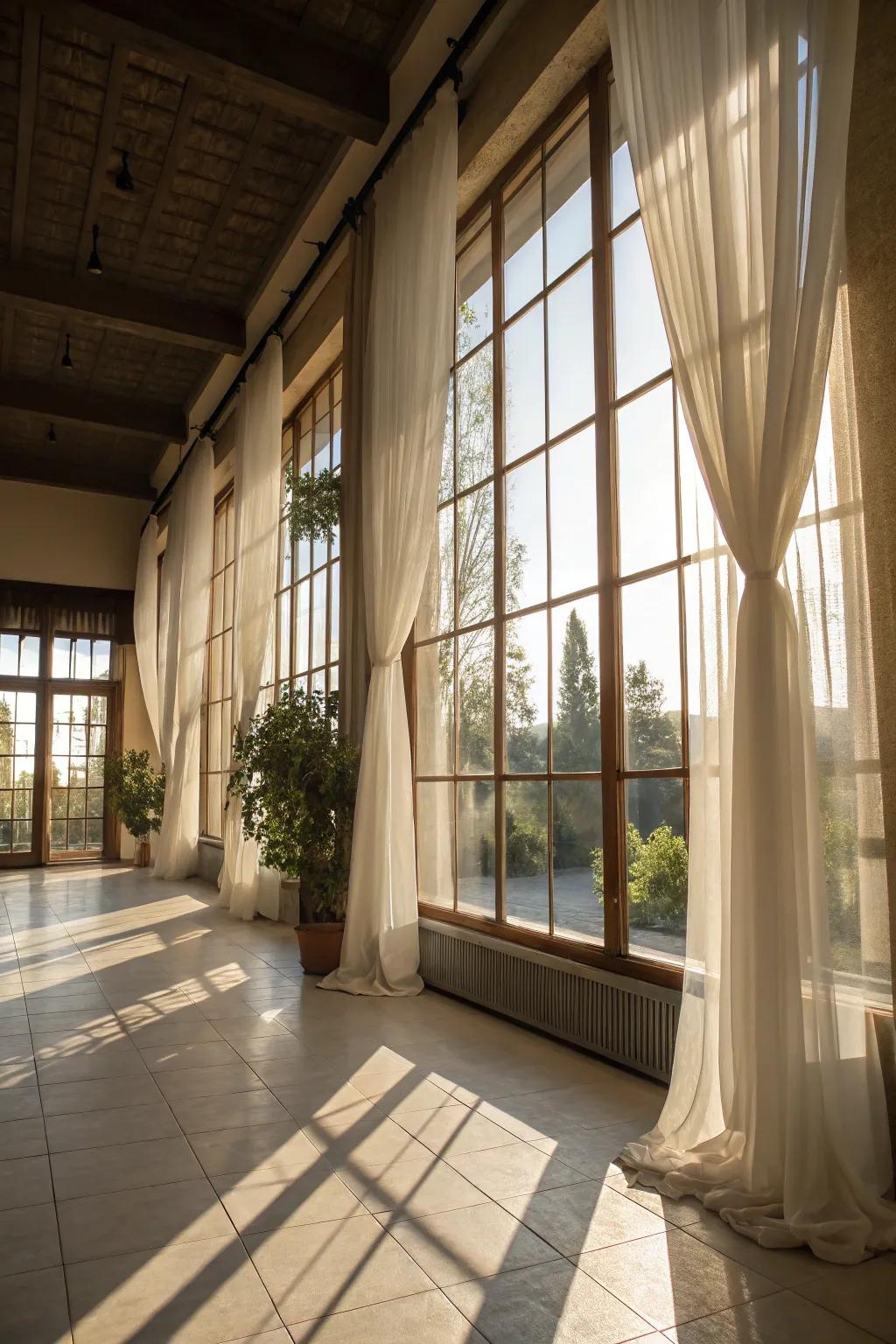 A luminous room celebrating natural light through expansive windows and sheer drapes.