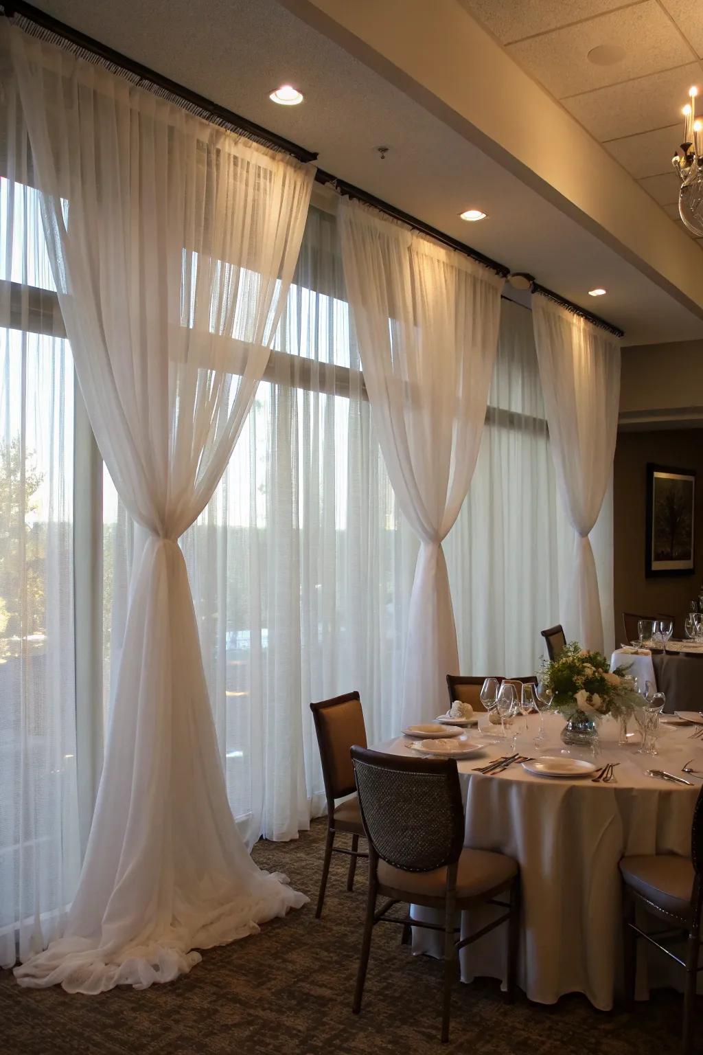 Sheer drapes bring elegance to a temporary wall in a dining area.