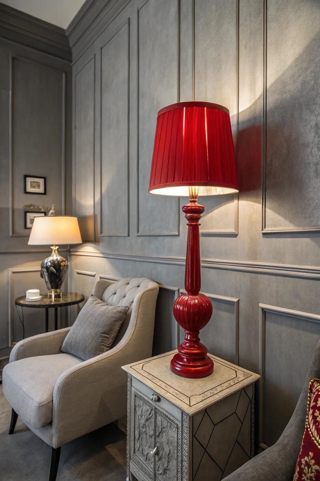 A crimson lamp adds flair to a grey-toned room.
