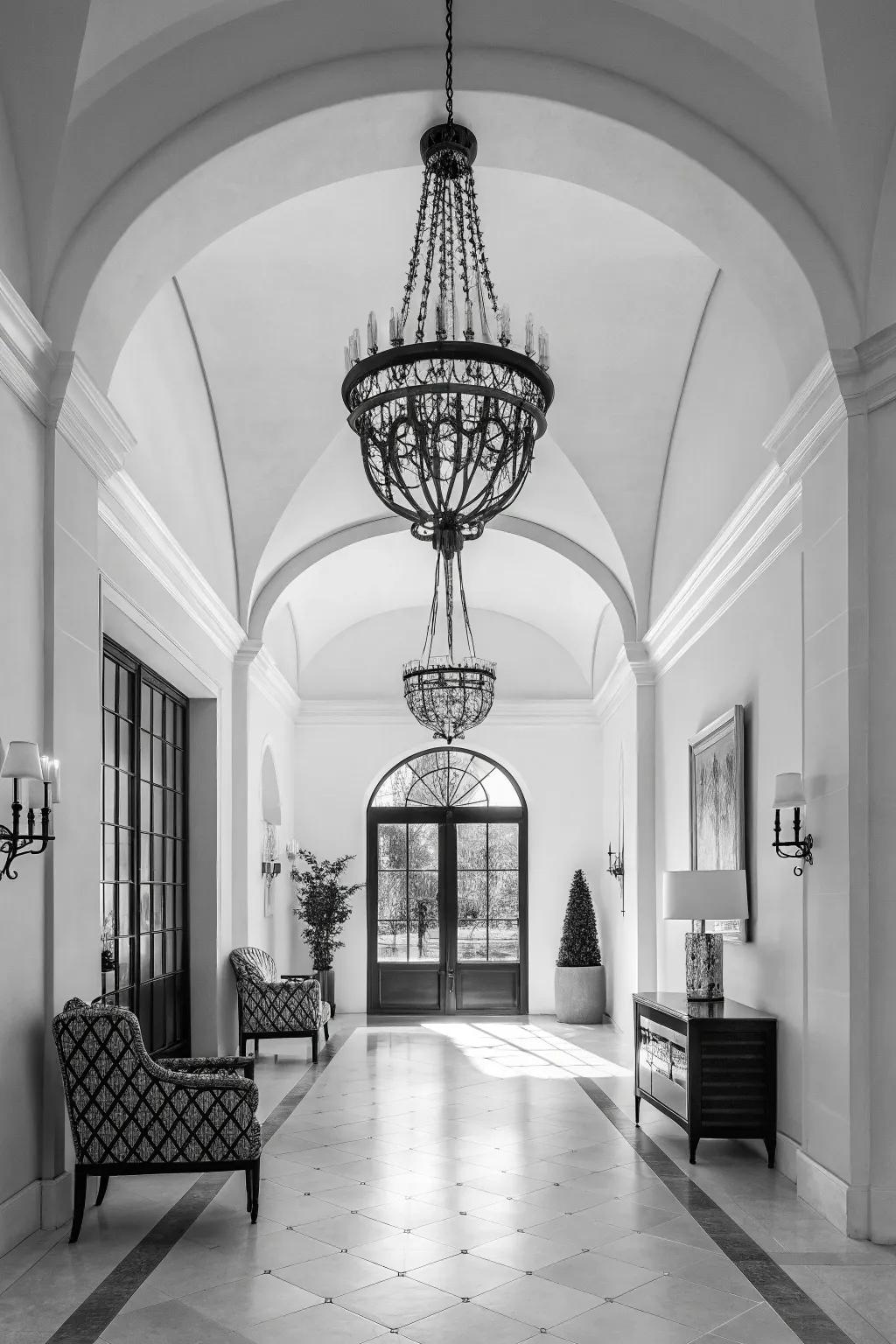 A monochrome chandelier incorporates sophistication to this modern foyer.