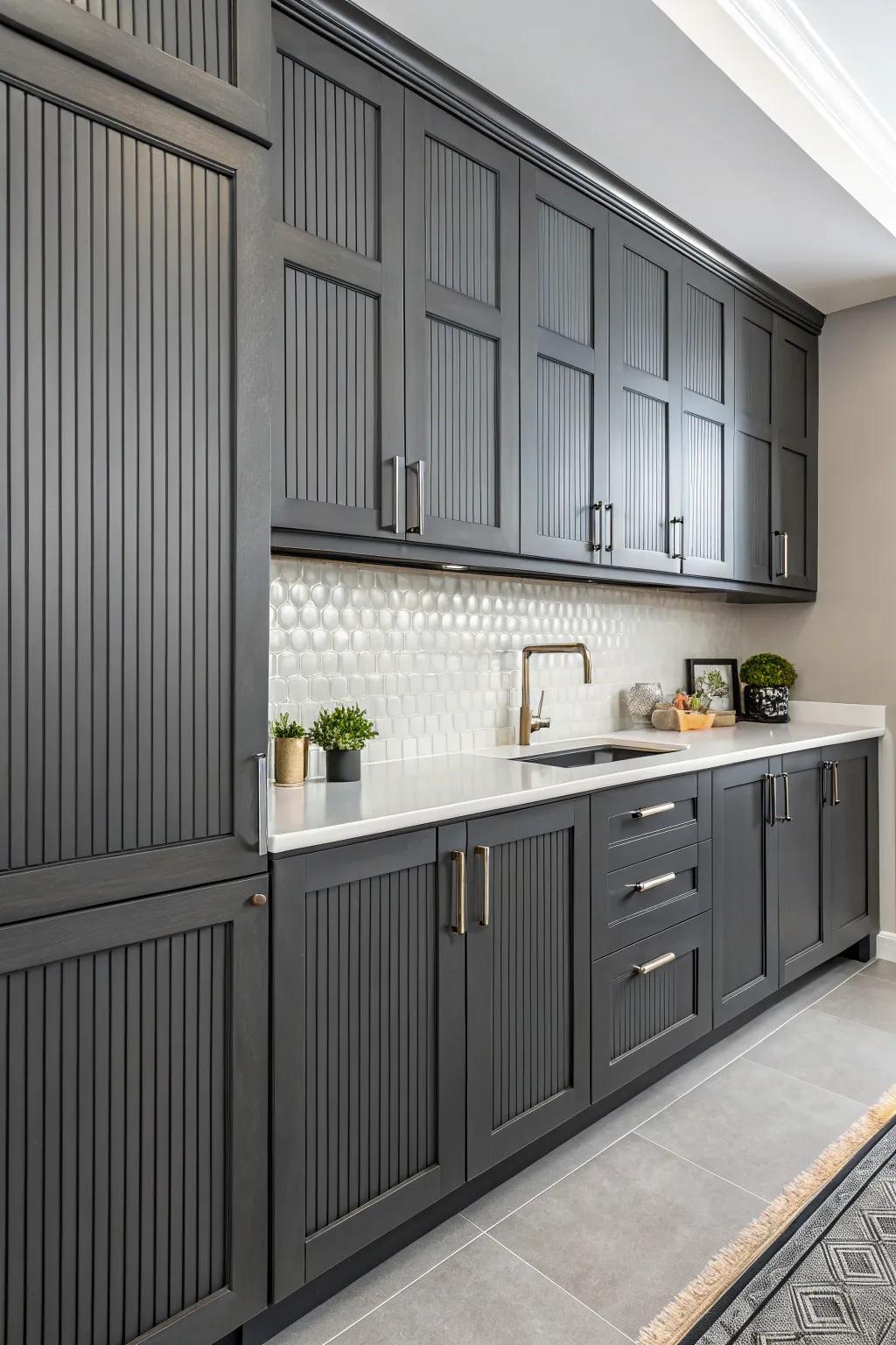Vertical lines introducing texture and height to the deep charcoal cabinets.