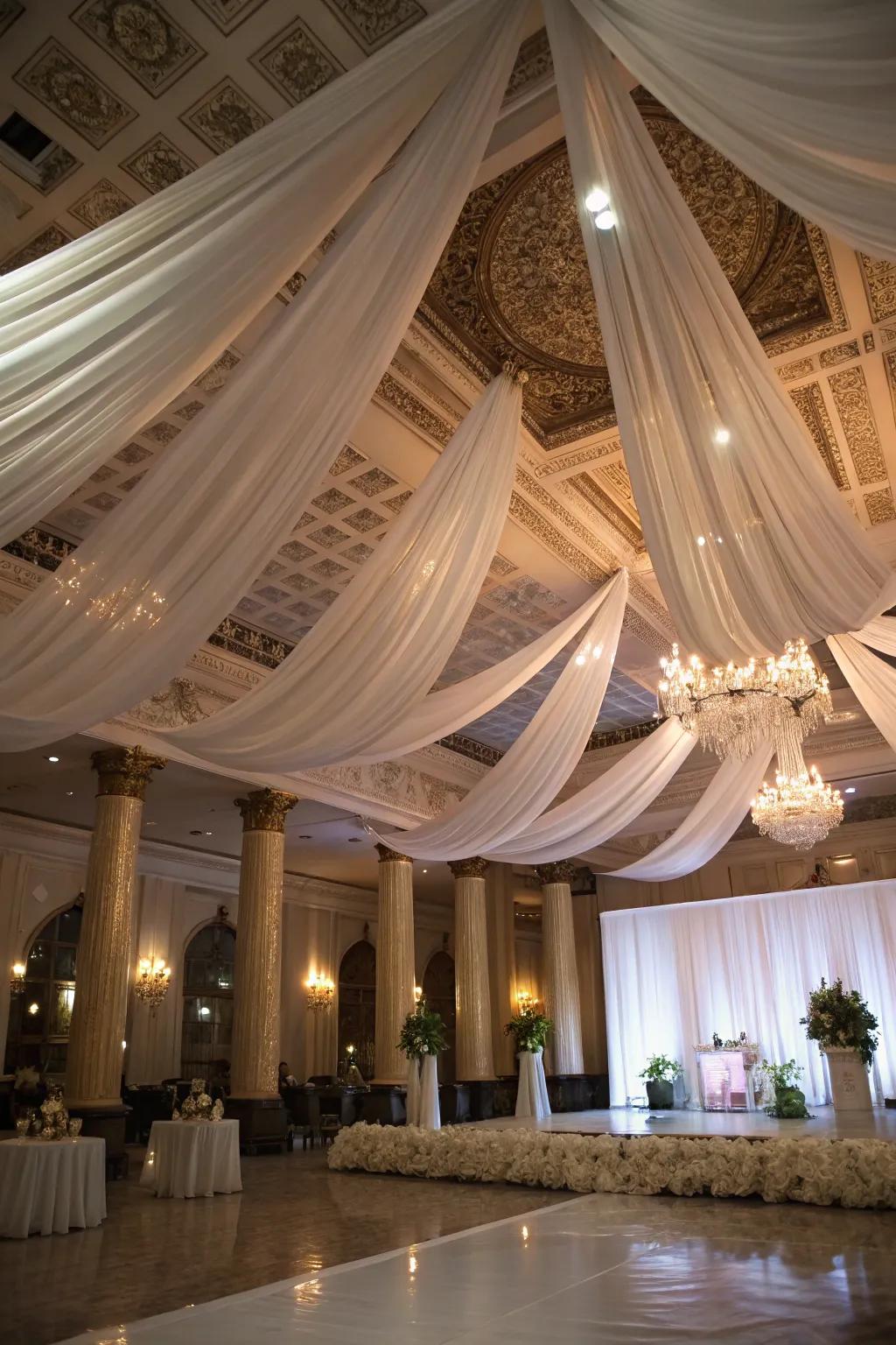 A wedding venue transformed with dramatic overhead cloth, adding elegance.