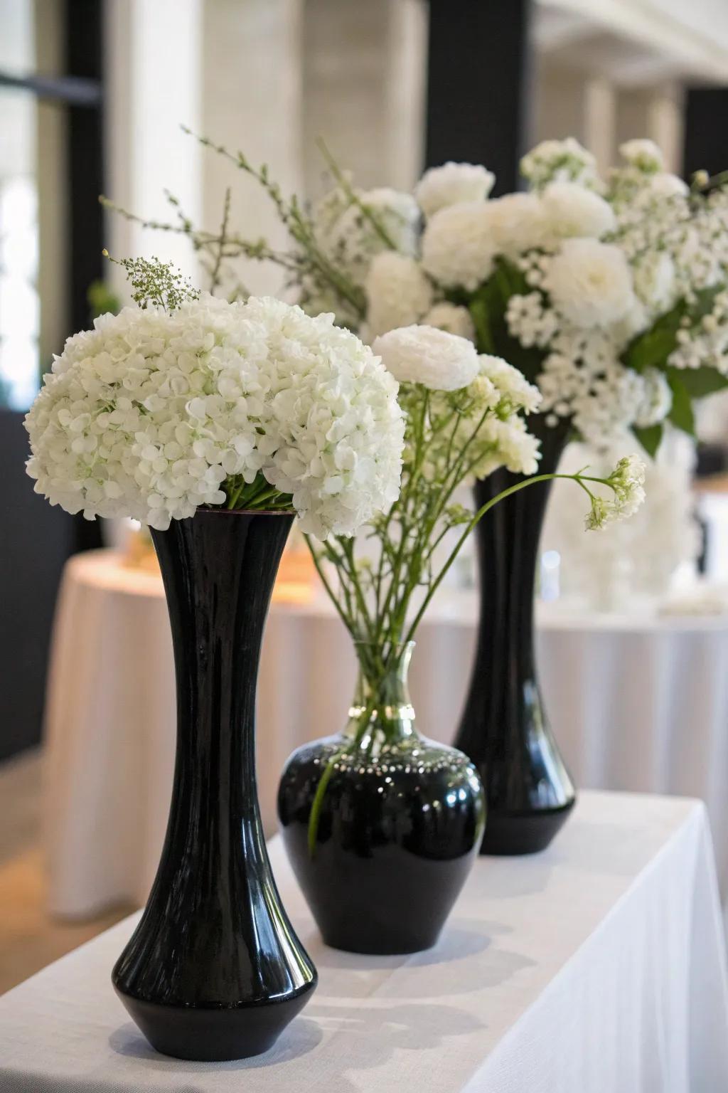 Elegant white flowers contrasted against sleek black vases.