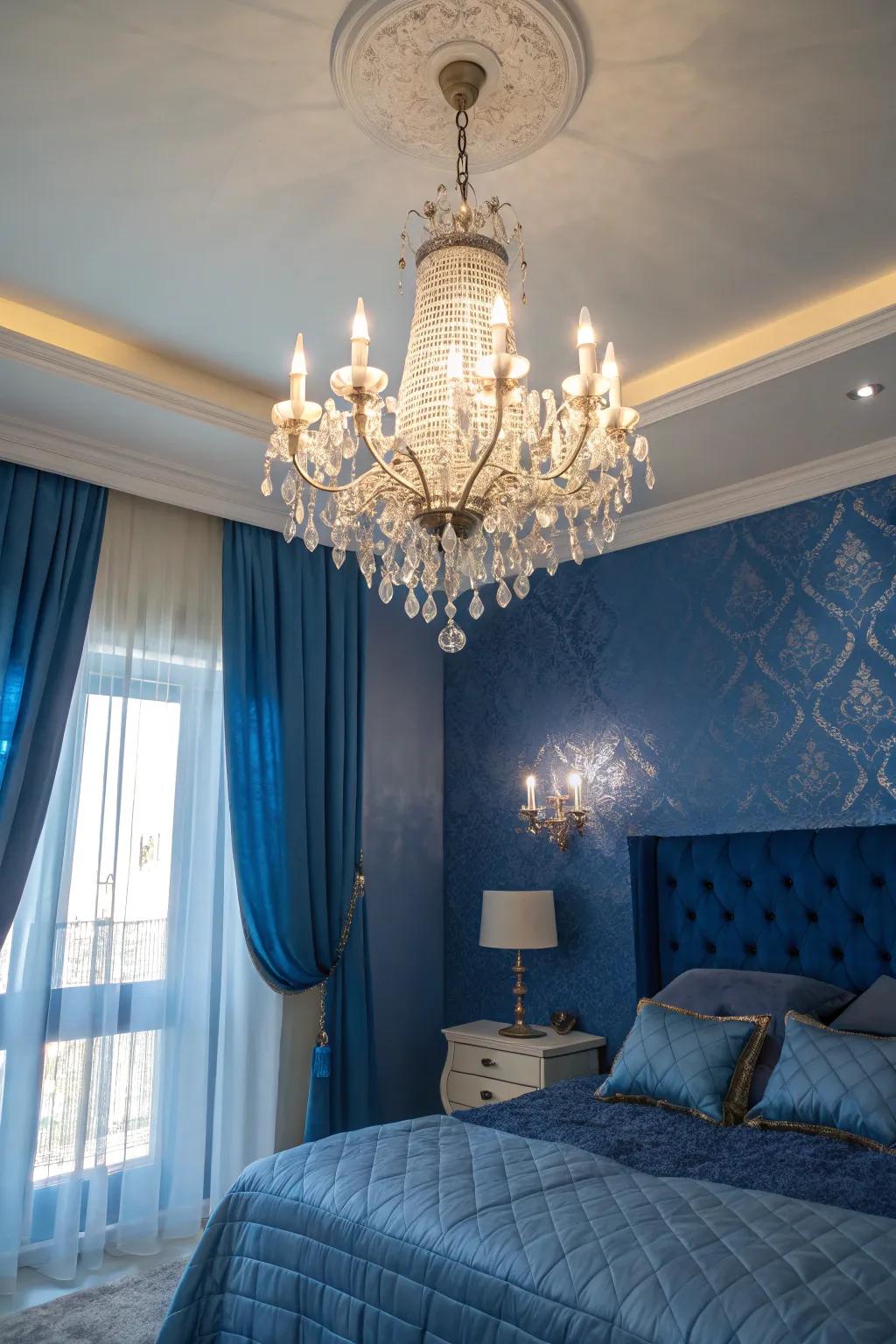 A crystalline suspended light adds sophistication to a regal blue themed chamber.