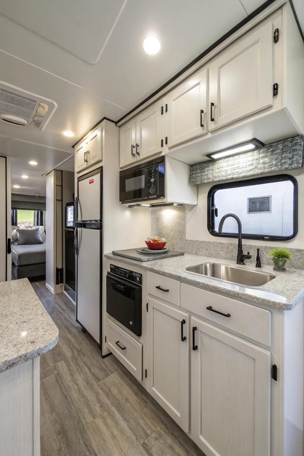 A modern camper kitchen featuring streamlined cabinets and compact appliances for efficient meal preparation.