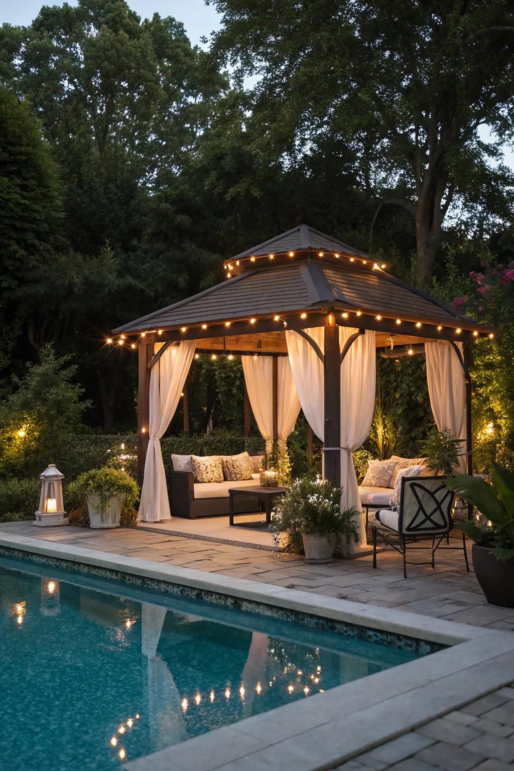 Overhead lighting within a gazebo fashions a comfortable gathering spot adjacent to the pool.
