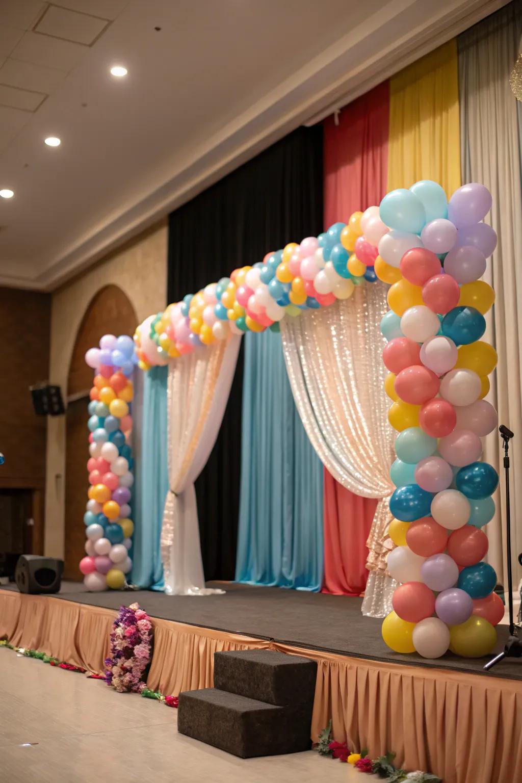 A cohesive stage design with balloons and refined drapes.